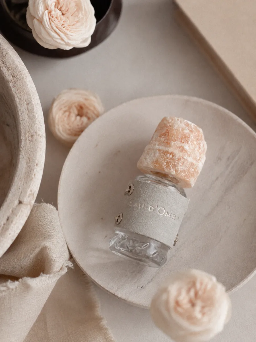 Флакон Eau d'Ombre на тарелке с розами